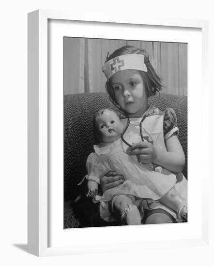 Evelyn Mott playing Nurse with doll as parents adjust children to abnormal conditions in wartime-Alfred Eisenstaedt-Framed Photographic Print