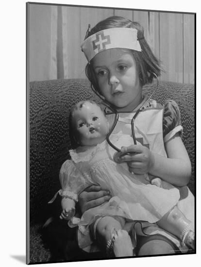 Evelyn Mott playing Nurse with doll as parents adjust children to abnormal conditions in wartime-Alfred Eisenstaedt-Mounted Photographic Print