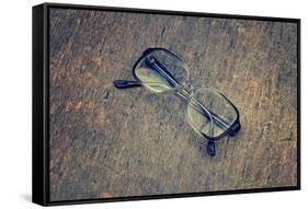 Eyeglasses Laying on a Grungy Wooden Background with Retro Filter Effect-Diplomedia-Framed Stretched Canvas