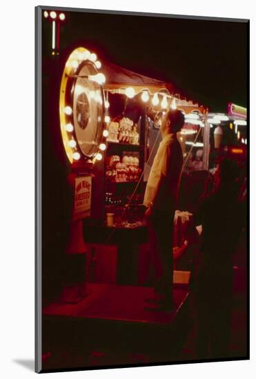 Fairgoer Stands on a 'Guess Your Weight' Carnival Game at the Iowa State Fair, 1955-John Dominis-Mounted Photographic Print