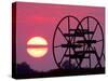 Farm Equipment is Silhouetted by a Setting Sun-null-Stretched Canvas