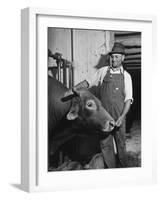 Farm Worker Petting One of the Cows Living on a Dairy Farm-Hansel Mieth-Framed Photographic Print