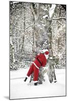 Father Christmas in Snow Behind Tree-null-Mounted Photographic Print