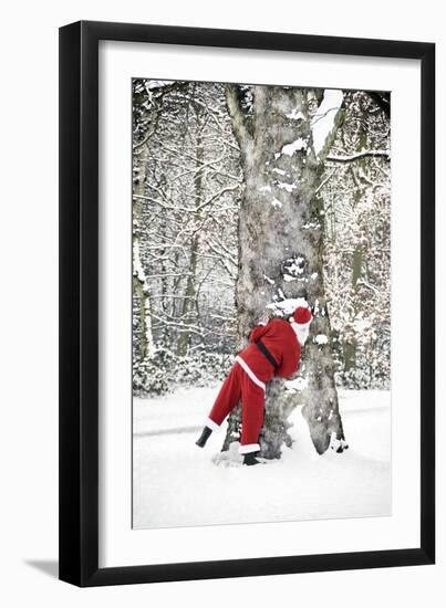 Father Christmas in Snow Behind Tree-null-Framed Photographic Print