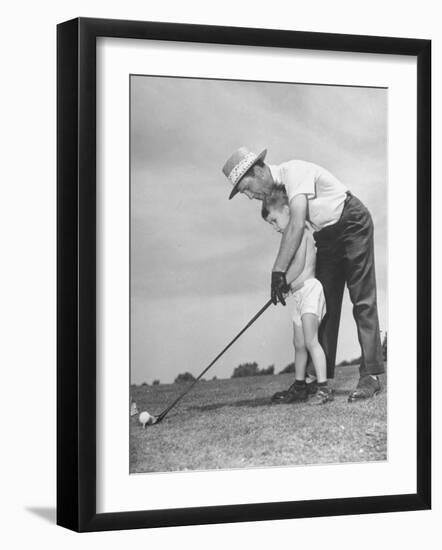 Father Teaching His Small Son How to Play Golf-null-Framed Photographic Print