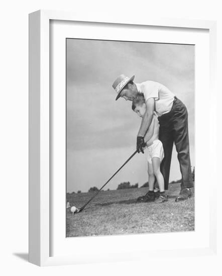 Father Teaching His Small Son How to Play Golf-null-Framed Photographic Print