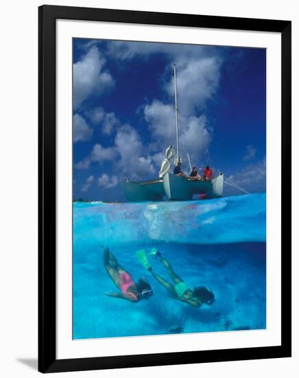 Female Divers Submerged Below Catamaran-Amos Nachoum-Framed Photographic Print