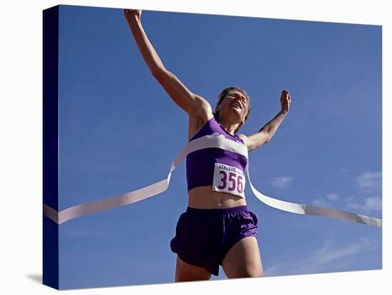 Female Runner Celebrates Victory at the Finish Line-null-Stretched Canvas