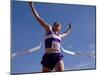 Female Runner Celebrates Victory at the Finish Line-null-Mounted Photographic Print
