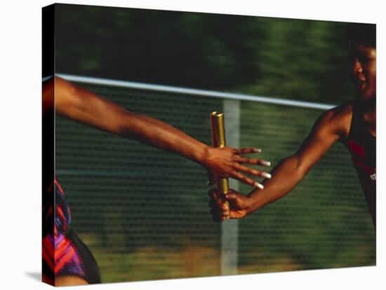 Female Runner Competing in a Relay Track Race-null-Stretched Canvas