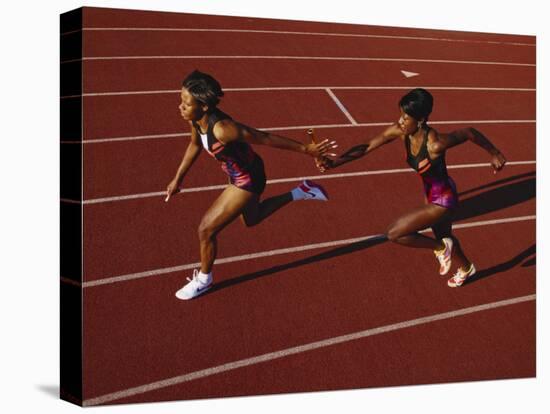 Female Runner Competing in a Relay Track Race-null-Stretched Canvas