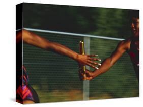 Female Runner Competing in a Relay Track Race-null-Stretched Canvas