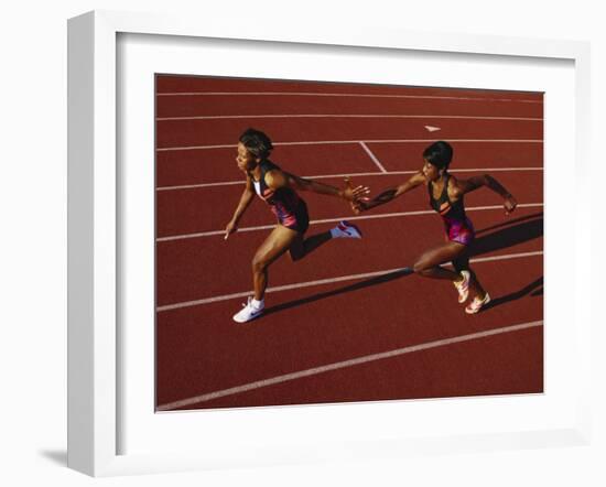 Female Runner Competing in a Relay Track Race-null-Framed Photographic Print