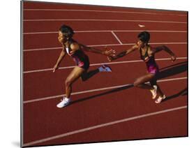Female Runner Competing in a Relay Track Race-null-Mounted Photographic Print