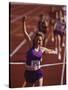 Female Runner Victorious at the Finish Line in a Track Race-null-Stretched Canvas