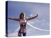 Female Runner Victorious at the Finish Line in a Track Race-null-Stretched Canvas