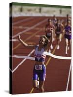 Female Runner Victorious at the Finish Line in a Track Race-null-Stretched Canvas