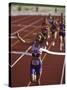 Female Runner Victorious at the Finish Line in a Track Race-null-Stretched Canvas