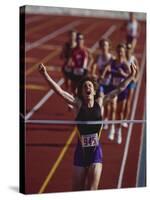 Female Runner Victorious at the Finish Line in a Track Race-null-Stretched Canvas