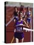 Female Runner Victorious at the Finish Line in a Track Race-null-Stretched Canvas