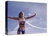 Female Runner Victorious at the Finish Line in a Track Race-null-Stretched Canvas