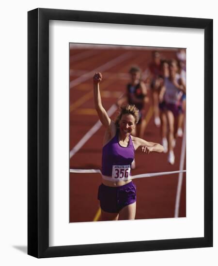 Female Runner Victorious at the Finish Line in a Track Race-null-Framed Premium Photographic Print