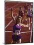 Female Runner Victorious at the Finish Line in a Track Race-null-Mounted Premium Photographic Print