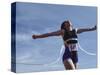 Female Runner Victorious at the Finish Line in a Track Race-null-Stretched Canvas