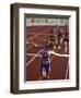 Female Runner Victorious at the Finish Line in a Track Race-null-Framed Premium Photographic Print