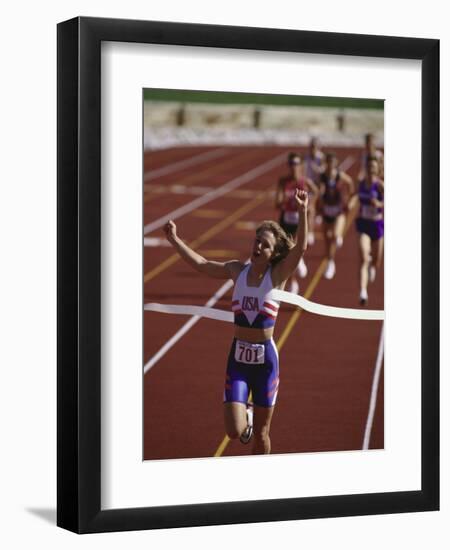 Female Runner Victorious at the Finish Line in a Track Race-null-Framed Premium Photographic Print