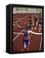 Female Runner Victorious at the Finish Line in a Track Race-null-Framed Stretched Canvas