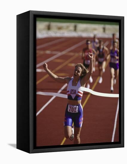 Female Runner Victorious at the Finish Line in a Track Race-null-Framed Stretched Canvas