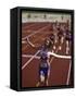 Female Runner Victorious at the Finish Line in a Track Race-null-Framed Stretched Canvas