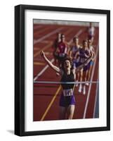 Female Runner Victorious at the Finish Line in a Track Race-null-Framed Photographic Print