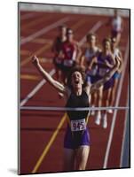 Female Runner Victorious at the Finish Line in a Track Race-null-Mounted Photographic Print