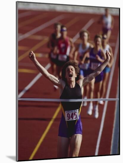 Female Runner Victorious at the Finish Line in a Track Race-null-Mounted Photographic Print