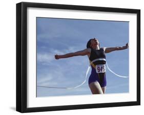 Female Runner Victorious at the Finish Line in a Track Race-null-Framed Photographic Print