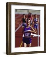 Female Runner Victorious at the Finish Line in a Track Race-null-Framed Photographic Print