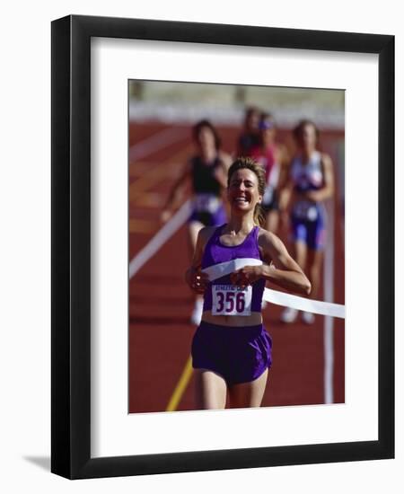 Female Runner Victorious at the Finish Line in a Track Race-null-Framed Photographic Print