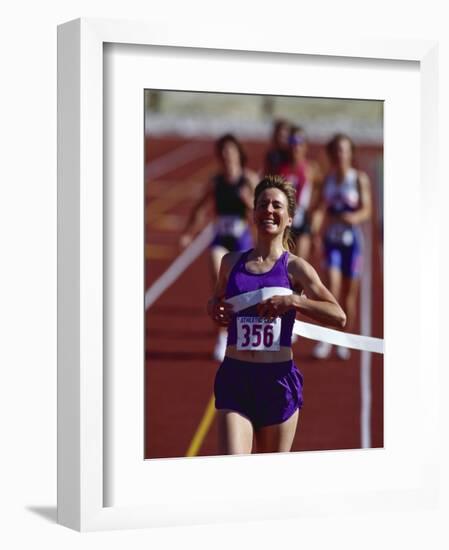 Female Runner Victorious at the Finish Line in a Track Race-null-Framed Photographic Print