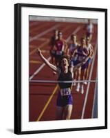 Female Runner Victorious at the Finish Line in a Track Race-null-Framed Photographic Print