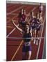 Female Runner Victorious at the Finish Line in a Track Race-null-Mounted Photographic Print