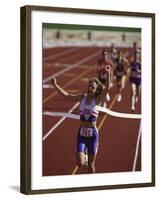 Female Runner Victorious at the Finish Line in a Track Race-null-Framed Photographic Print