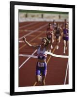 Female Runner Victorious at the Finish Line in a Track Race-null-Framed Photographic Print