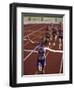 Female Runner Victorious at the Finish Line in a Track Race-null-Framed Photographic Print