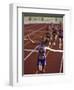 Female Runner Victorious at the Finish Line in a Track Race-null-Framed Photographic Print