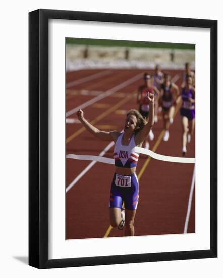 Female Runner Victorious at the Finish Line in a Track Race-null-Framed Photographic Print