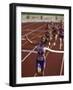 Female Runner Victorious at the Finish Line in a Track Race-null-Framed Photographic Print