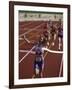 Female Runner Victorious at the Finish Line in a Track Race-null-Framed Photographic Print