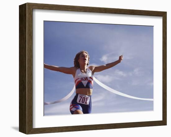 Female Runner Victorious at the Finish Line in a Track Race-null-Framed Photographic Print